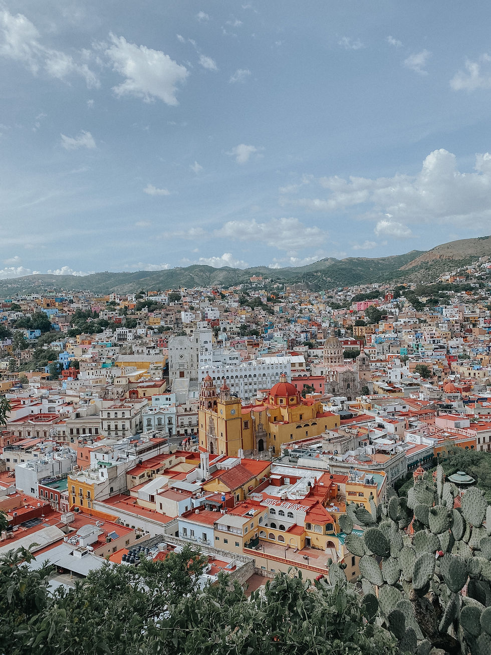 Imagen de la ciudad de Guanajuato con techos de casas en color rojo y diferentes colores que van desde los blancos degradando a rojo.