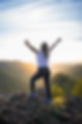 Hiking woman in a white shirt raising her arms at sunrise. Image by Danilo Ćalić