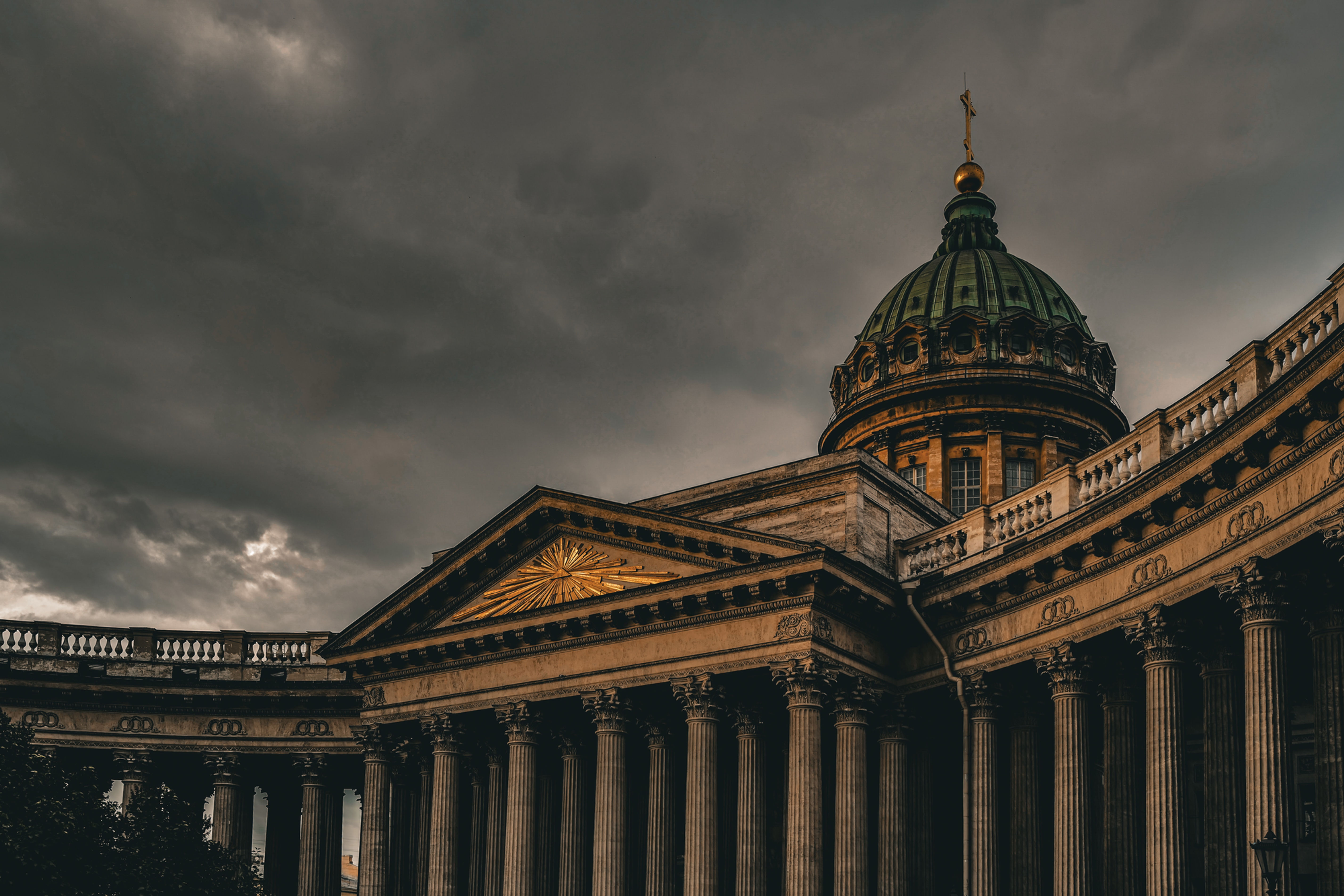 Kazan Cathedral with a large dome and columns under a dramatic cloudy sky