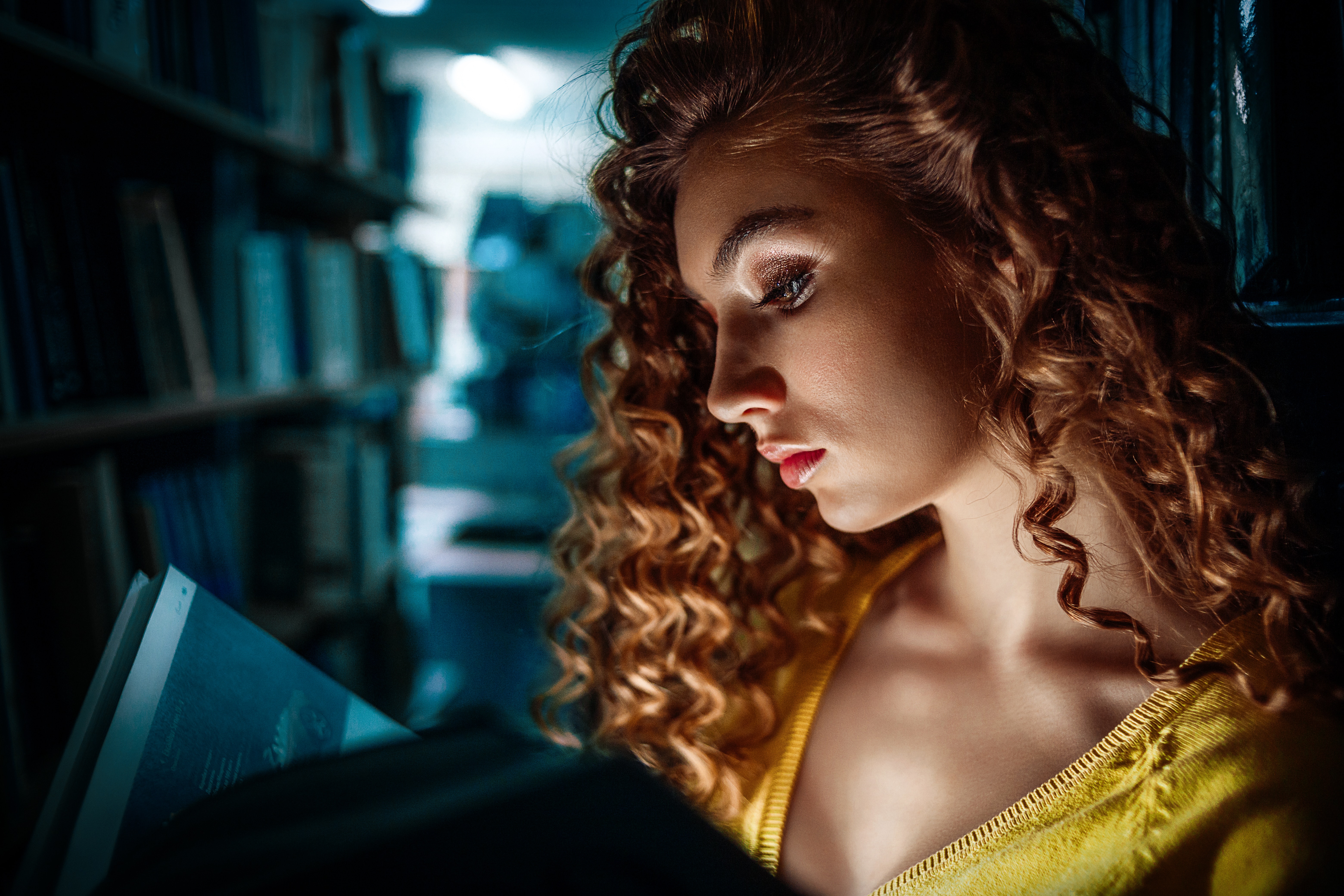 A woman reading an erotic adult fiction book by torch light