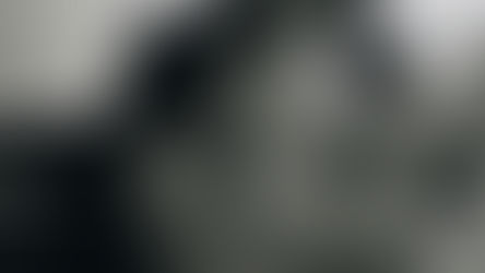 Baby resting in an adult’s arms while drinking from a bottle, showing a calm feeding moment that reflects how to transition from formula to milk.