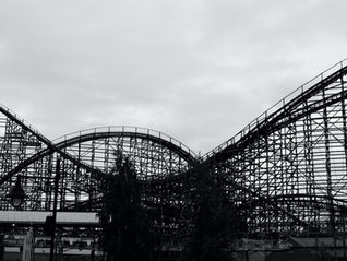 A black and white image of a wooden rollercoaster. The ups and downs of blood sugar can make us feel tired, cranky and craving more food.