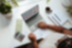 Image of someone typing on a computer and sitting at a table