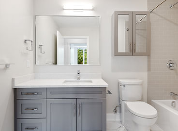 Guest bathroom featuring a white bathtub with elegant tile surround and modern chrome fixtures