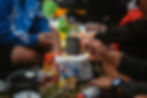 Group of people using cups and different camping equipement