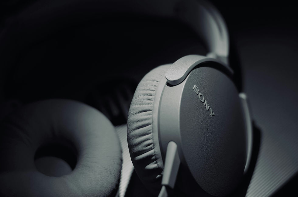Close-up of gray Sony over-ear headphones in a dark moody setting, with the SONY logo visible on the earcup.