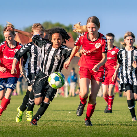 School Girls Playing Football on a Grass Pitch