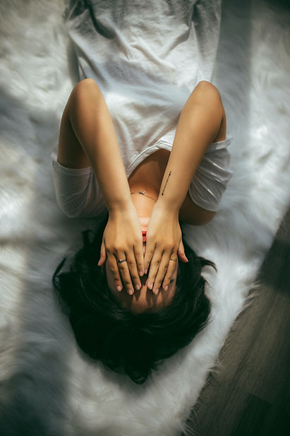 Woman with her hands over her face, dealing with spiritual burn out