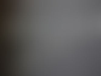 White AirPods mounted on a dark wall form musical notes on a staff with a treble clef, playful and minimalist.