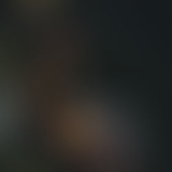 a graduate beams with pride, seated in her cap and gown.