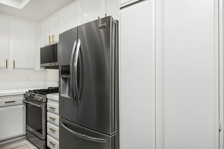 Modern kitchen with a stainless steel fridge, black oven