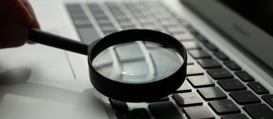 Uma lupa em cima do teclado de um laptop