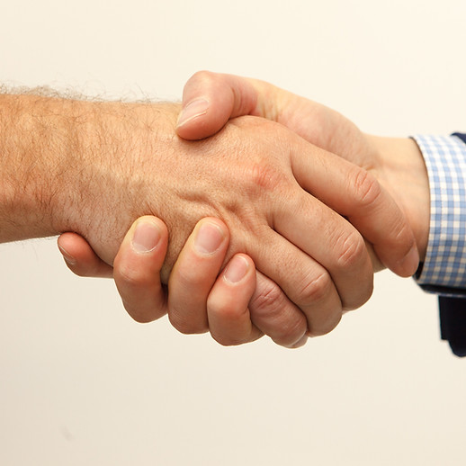 Two people shaking hands, one wearing a blue suit jacket