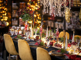 Mesa de Natal elegante com tons de vermelho e dourado, pinheiros brancos e decoração harmoniosa, criando uma atmosfera acolhedora e cheia de boas vibrações.