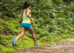 Image of a woman running in forest.