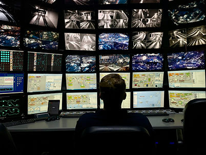 Security operator monitoring live CCTV camera feeds on multiple screens
