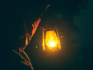 a person holding a lantern in the dark