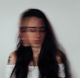Woman with a blurred face expressing anxiety and emotional overwhelm, representing women seeking anxiety therapy in Illinois and online support using somatic therapy and nervous system regulation.