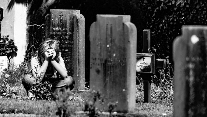 woman grieving next to a grave