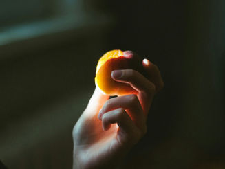 hand holding a small orange