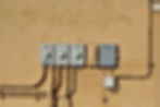 Outdoor electrical meters and circuit boxes mounted on a building wall