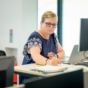 Kvinde arbejder koncentreret på et lyst kontor