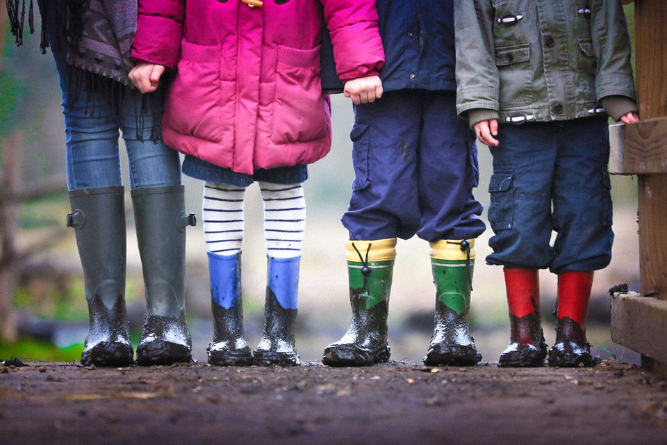 Children Photography by Blake Ferguson depicts a Group of Children Holding Hands with their Rubber Boots in Ontario, Canada.