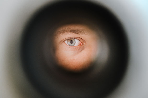 Person looking through a hole, you can see their eye