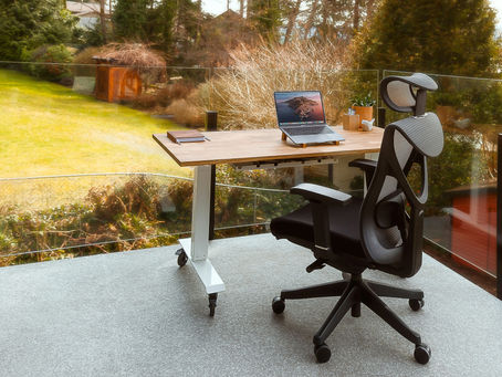 Calm outdoor workspace with a desk, laptop, and chair overlooking greenery, representing intentional career planning and clarity.