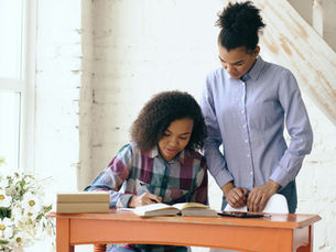 Young woman tutoring a teen at a desk