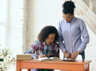 Young woman tutoring a teen at a desk