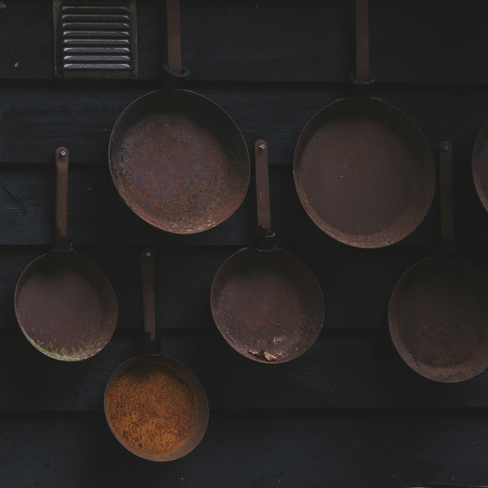 Old frying pans hanging on a dark wall