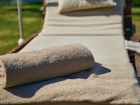 A rolled towel placed on an outdoor lounge chair
