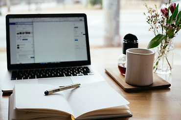 Lucy Patel - Laptop with coffee and diary on table - Group Programmes