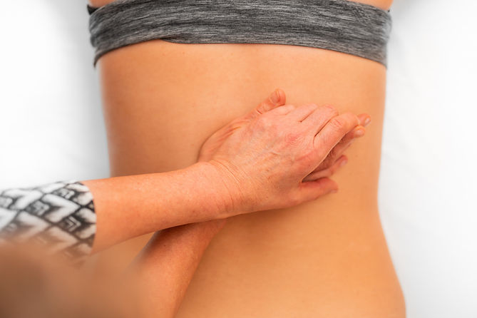 Hands massaging a person's lower back during Tui-Na therapy
