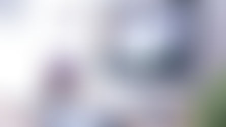 Moderner Arbeitsplatz mit iMac, MacBook, Tablet und Smartphone auf einem hellen Schreibtisch, ausgestattet mit einer Schreibtischlampe und Grafiktablett.