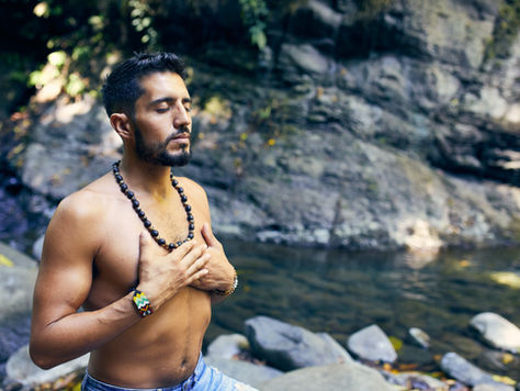 A man meditating on the side of the river, showcasing the importance of cultivating spiritual intelligence through psychotherapy