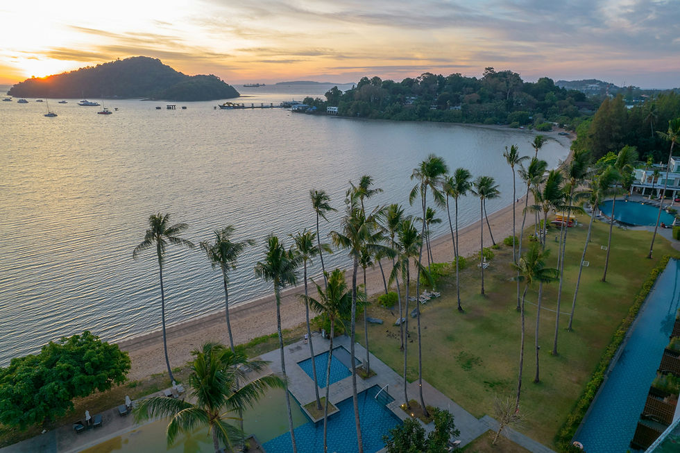 Phuket Panwa Beachfront Resort with palm trees, swimming pools, and private beach at sunset