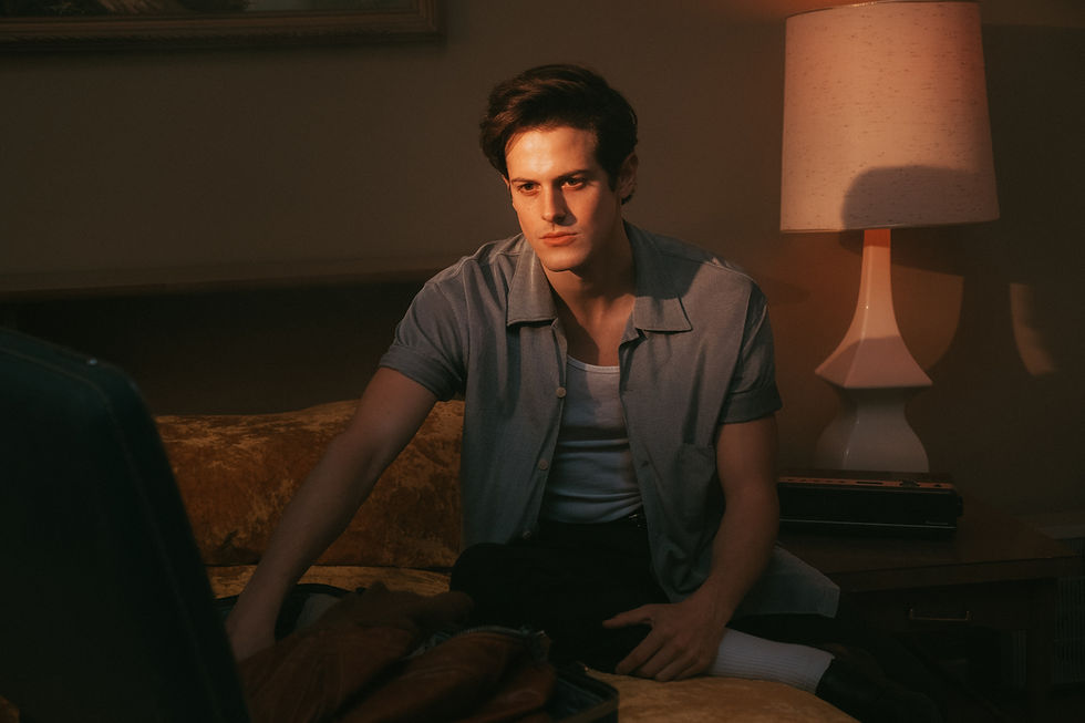 Young man starts packing his things in a dark hotel room before going somewhere different.