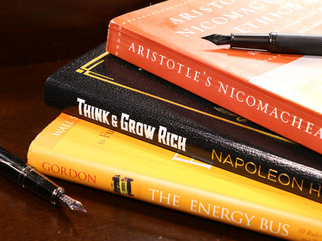 three business books stacked atop one another