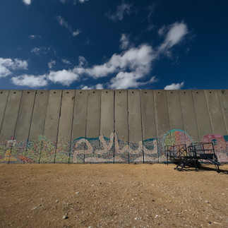 Concrete security wall with Peace in Arabic graffiti Gaza border Israel.