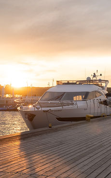 Private yacht moored at a wooden dock at sunset