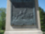 Bronze relief on a stone monument depicts Washington's river crossing.