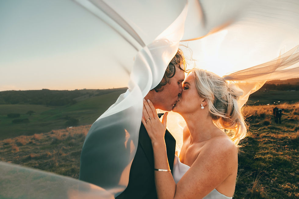 Bride and groom kissing, sunset, veil