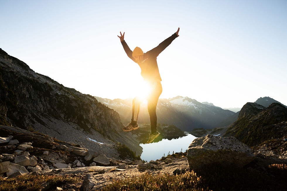 Young man jumping into the air with enthusiasm while outside on a hike