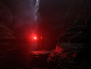 A glowing red light in a dark rocky cave