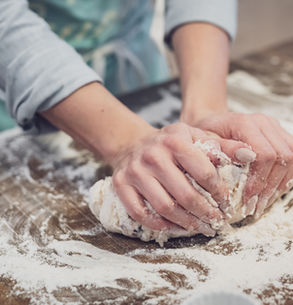 Sourdough baking class in Munich. Hands kneading dough on a floured surface