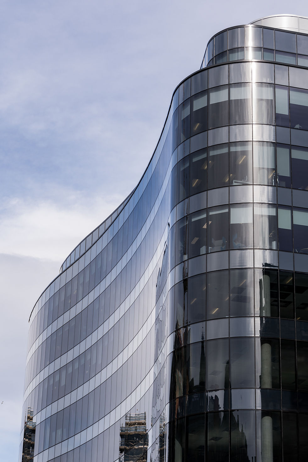 Curved skyscraper facade reflecting the sky