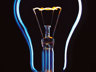 Close-up of a glowing light bulb against a dark background, showcasing vibrant blue and orange hues.