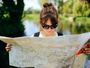 a person reading a map near a lake
